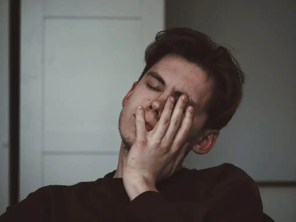 A young boy holding his head, appearing to be in pain